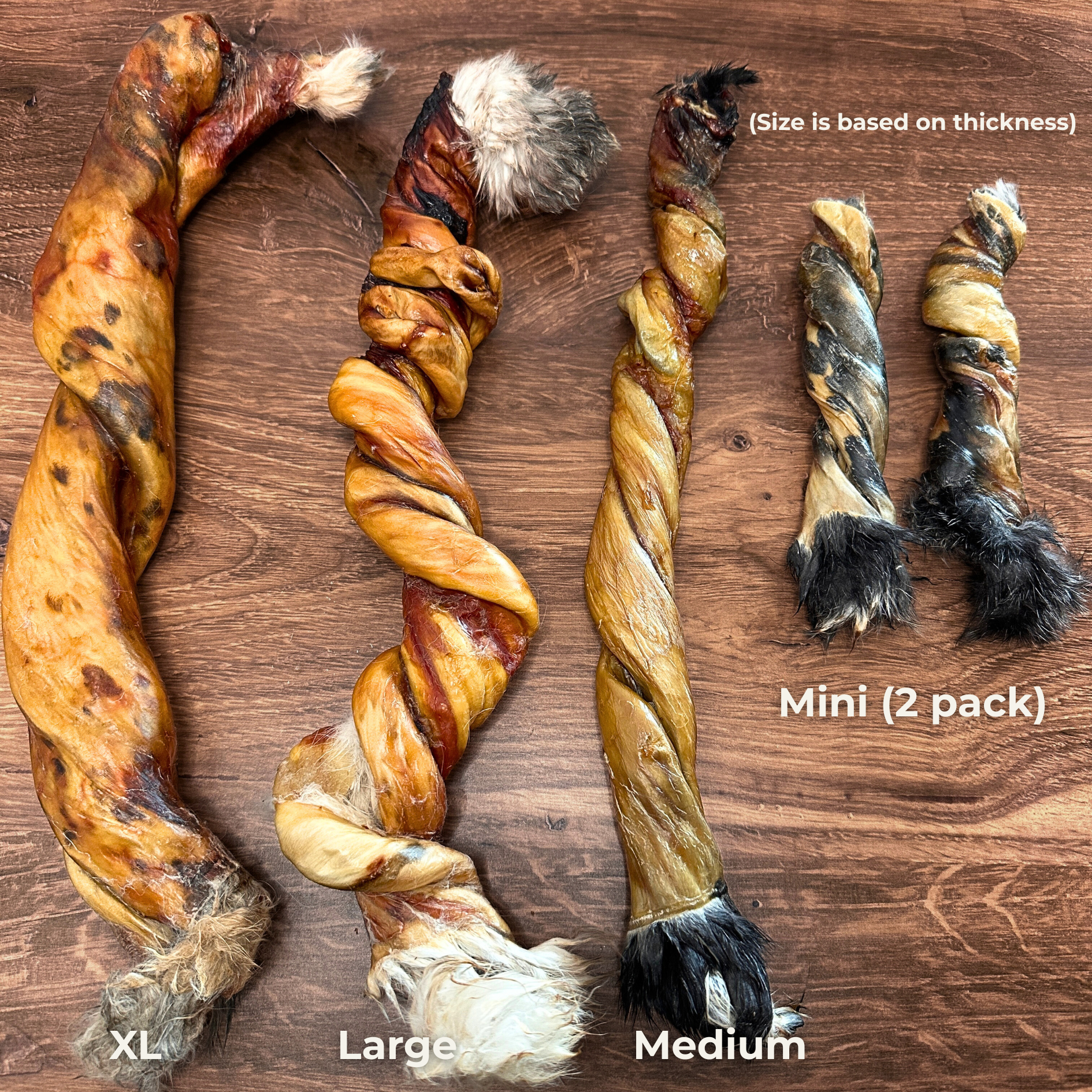 Rabbit hide twist dog chew different sizes on a wooden surface